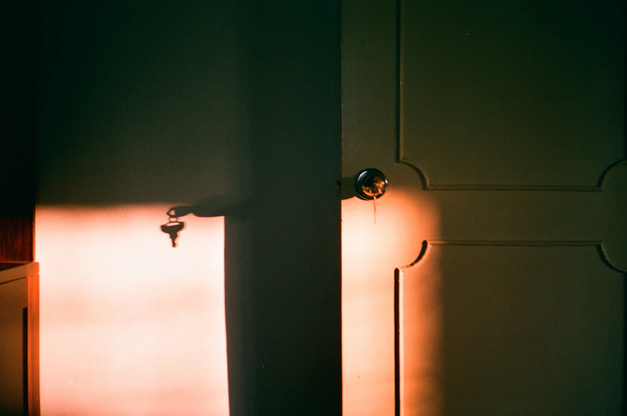 Keys hanging by a door left slightly open, light coming through