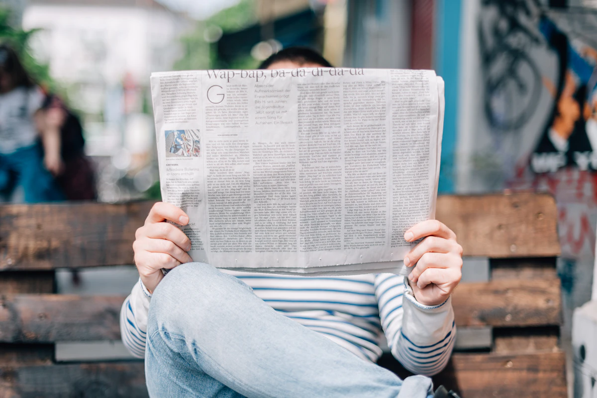 A man on a bench reading a newspaper